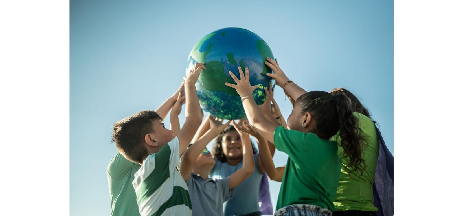 Children holding up globe
