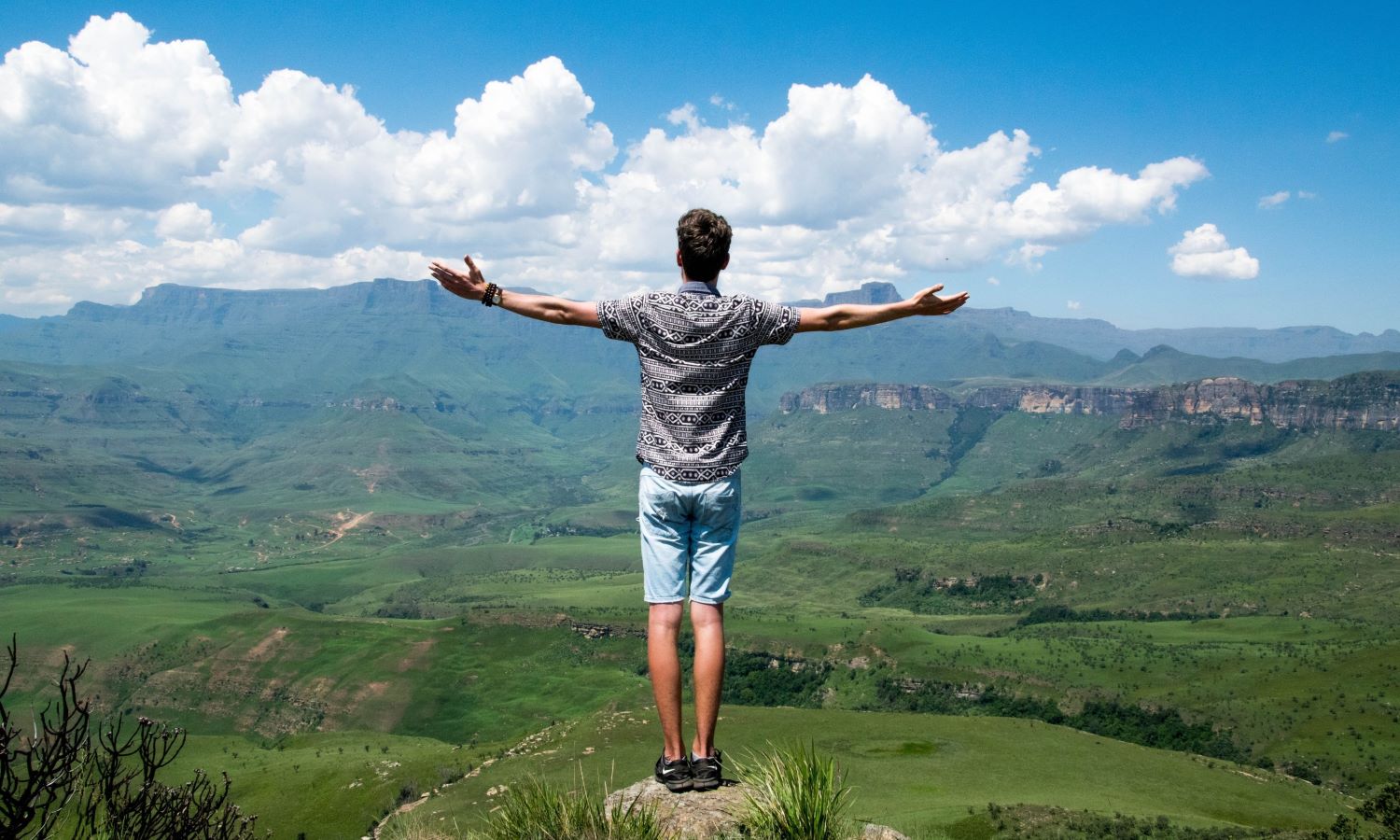 Freedom, man with outstretched arms looking over valley