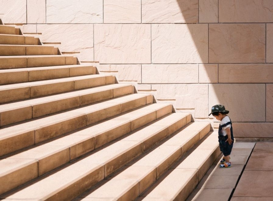 Child standing at the bottom of a great staircase