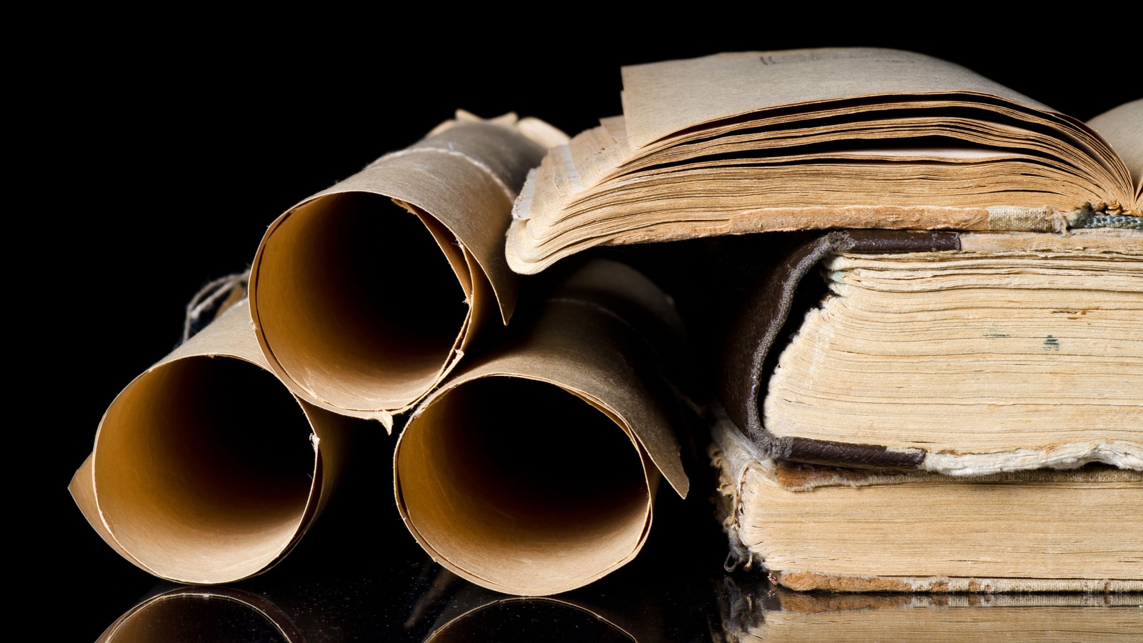 Many scrolls and old books on black background