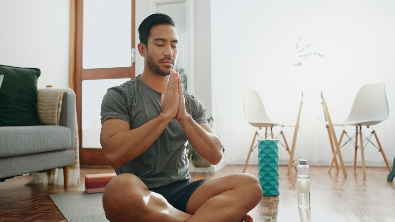 young man meditating inside his home