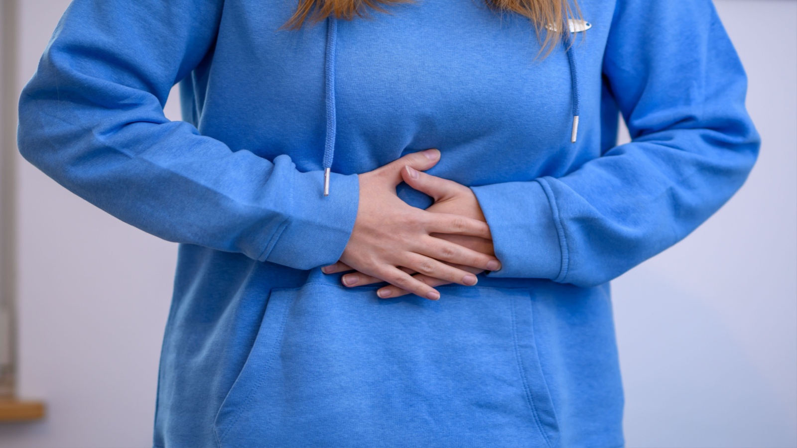 Woman holding her stomach feeling pain and discomfort