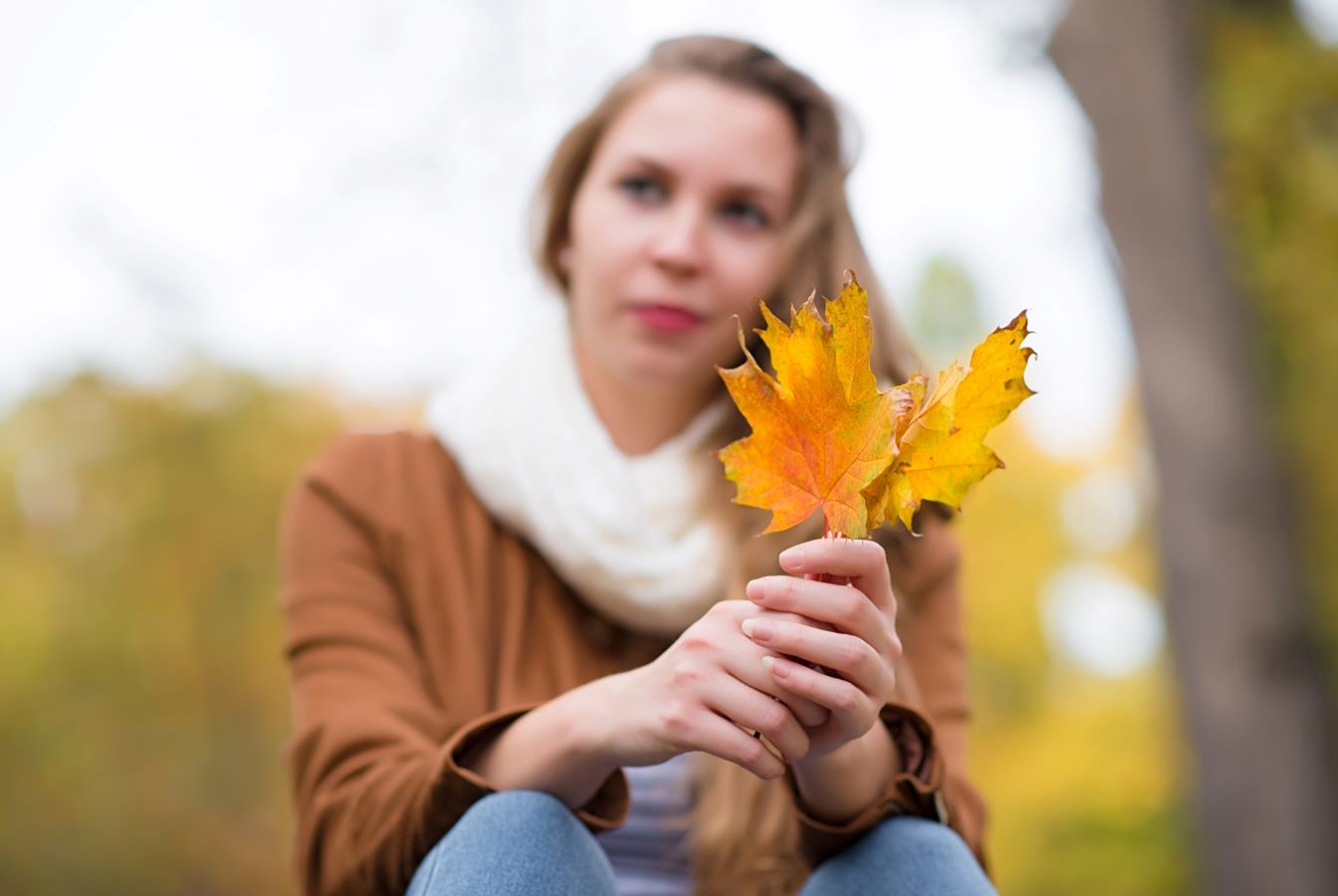 Woman holding golden maple leaves