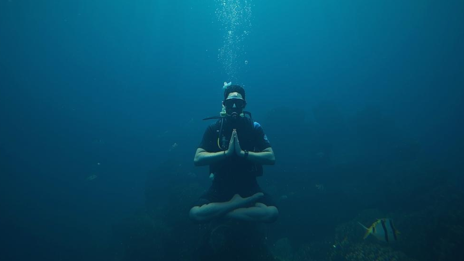 Person in lotus position while SCUBA diving
