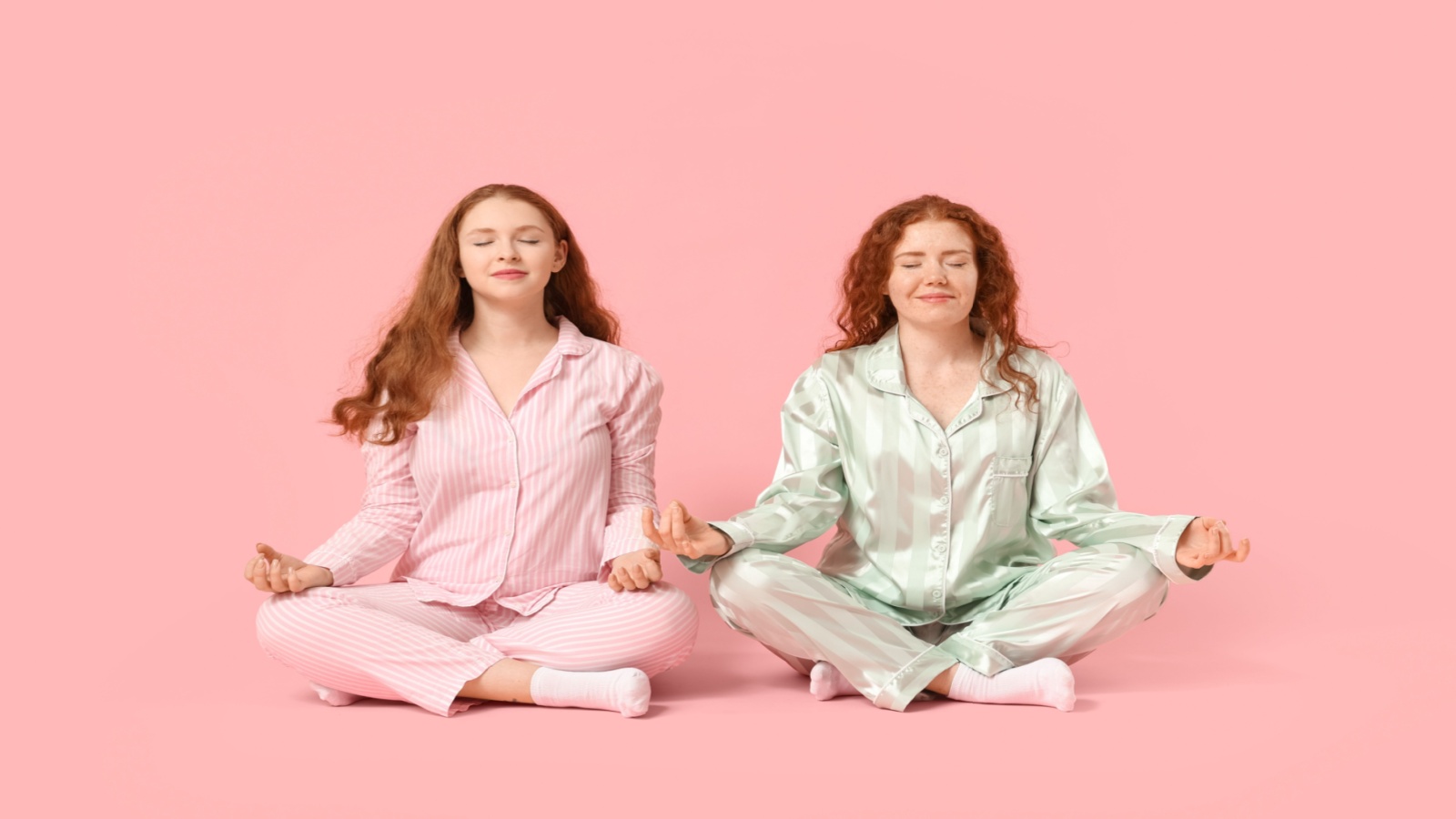 two red-head twin women meditate together side by side