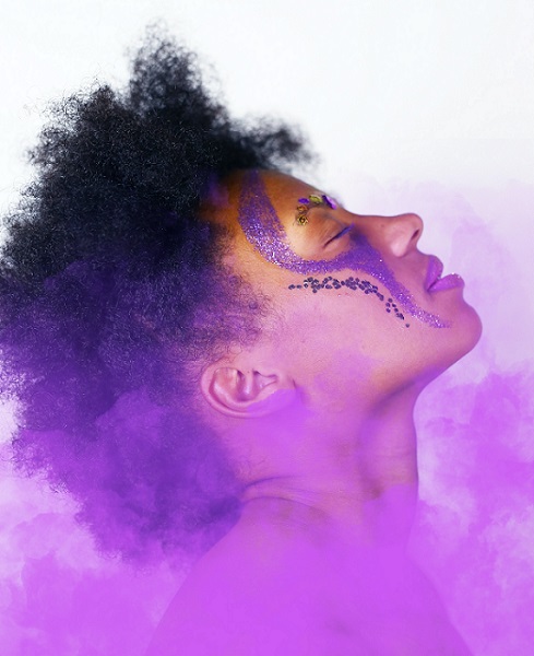 Side of woman's face in a purple mist
