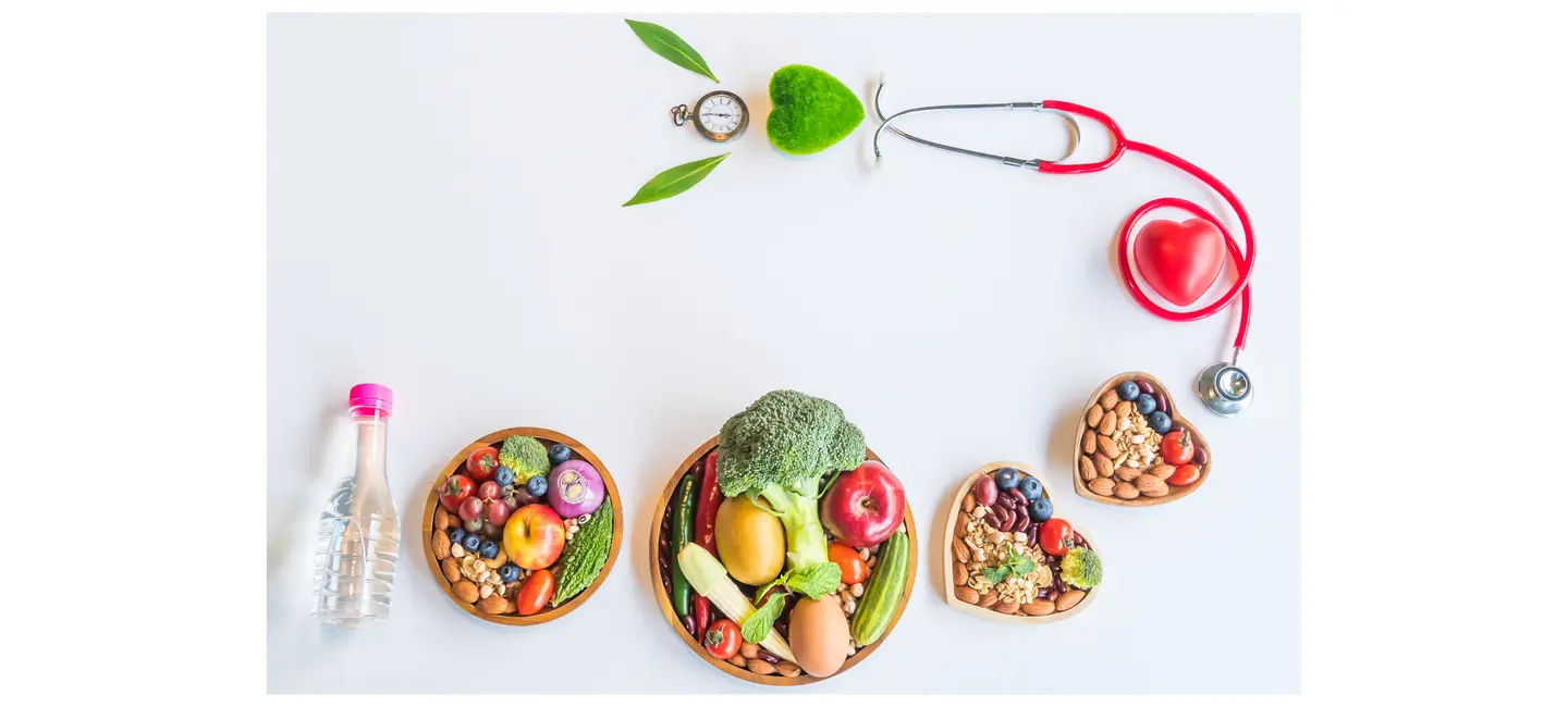healthy food in wooden bowls, bottled water, stethoscope, red and green heart