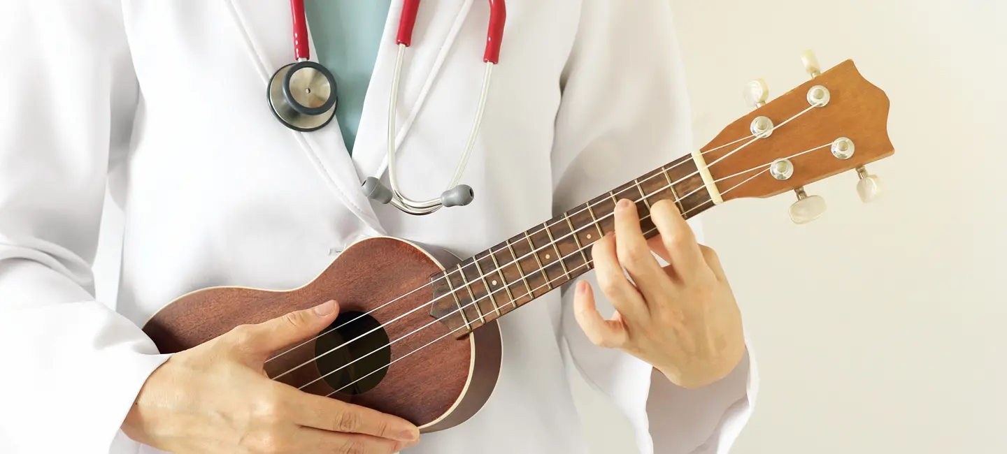 Doctor playing ukulele for Music therapy
