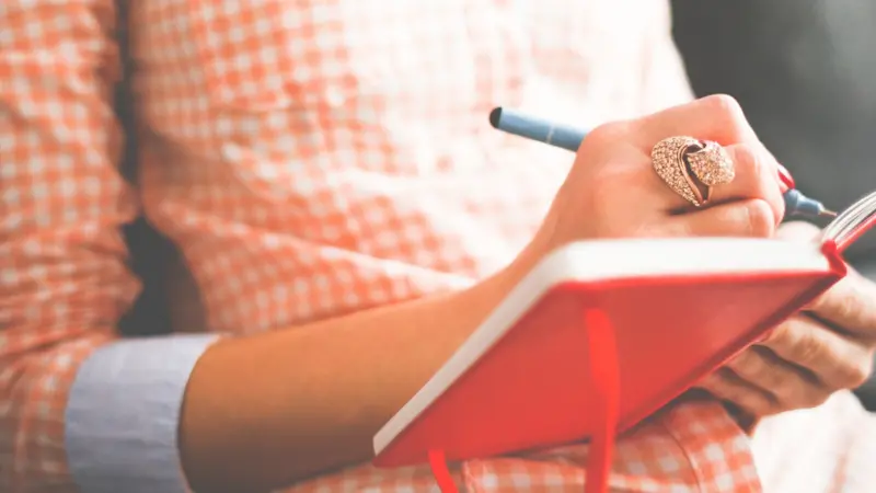 woman writes in notebook