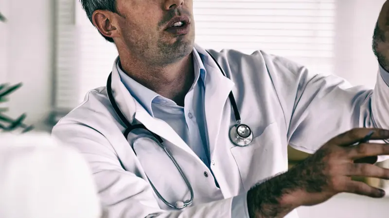 Doctor showing woman part of spine in clinic. Doctor showing woman part of spine in clinic.