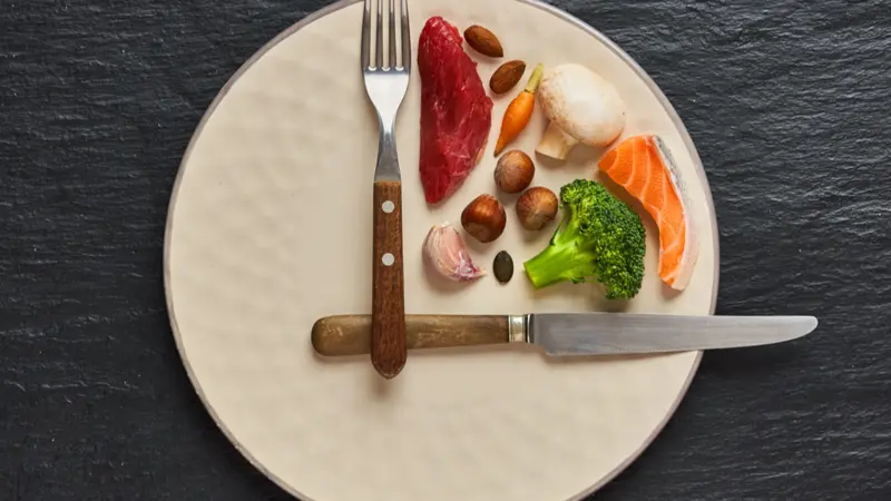 20:4 fasting diet concept. One third plate with healthy food and two third plate is empty.