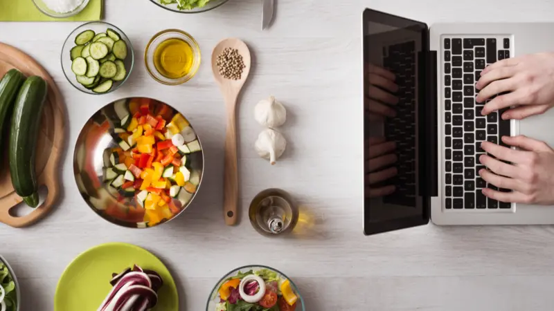laptop with food ingredients and fresh vegetables on the left, top view laptop with food ingredients and fresh vegetables on the left, top view