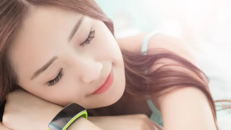 woman sleep with wearable smart watch on the bed