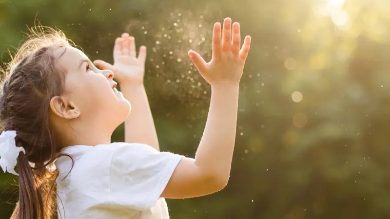 little girl catching soap bubbles in the summer