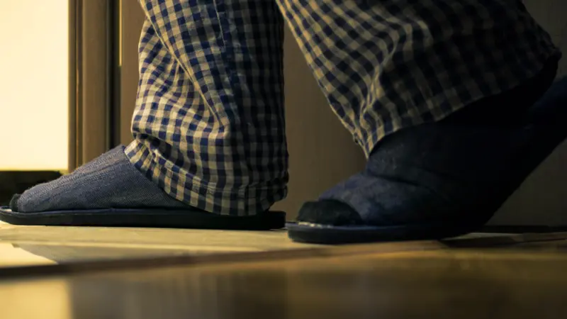Adult man in pajamas walks to a bathroom at the night Adult man in pajamas walks to a bathroom at the night