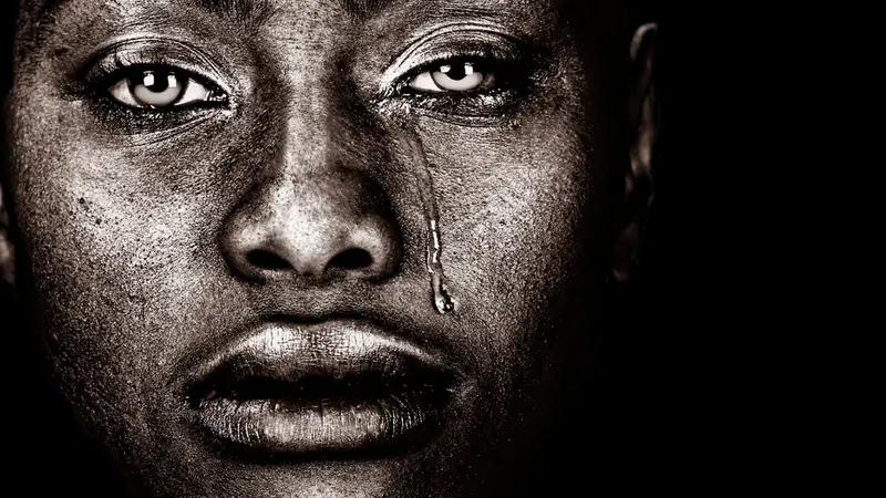 Black woman crying isolated on Black