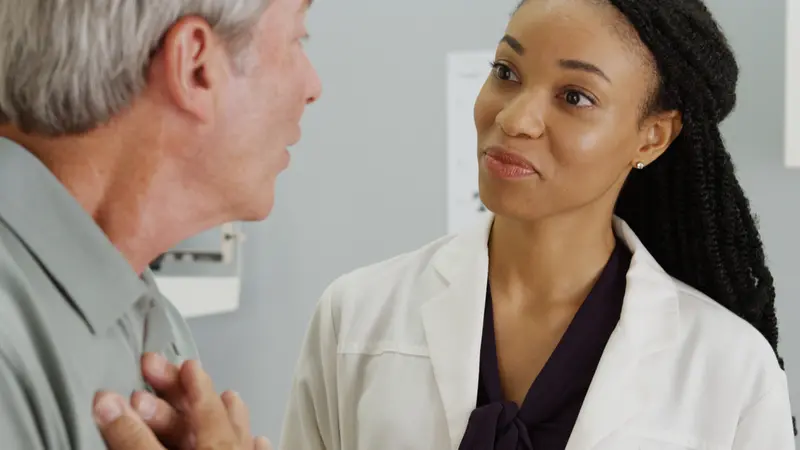 woman doctor listening to senior patient talking