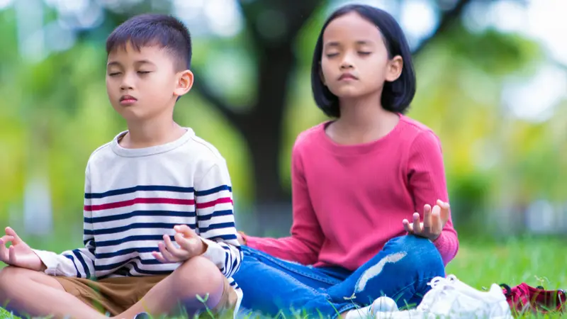 kids doing yoga pose in the park outdoor