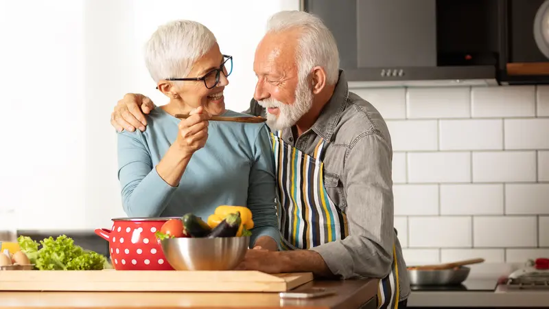 senior couple cooking a meal together at home