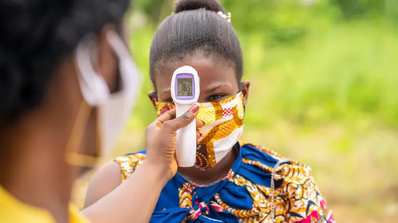 thermometer gun screen with the temperature digits-image of health official checking temperature during the covid-19 pandemic in Africa