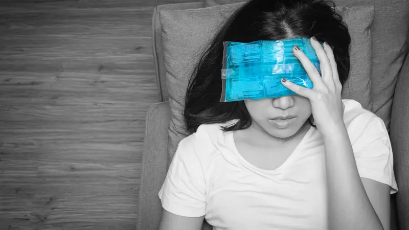 woman with cold pack on her forehead for relief headaches and migraines, black and white tone woman with cold pack on her forehead for relief headaches and migraines, black and white tone