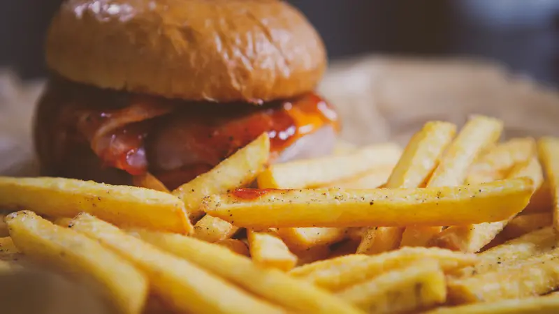 cheeseburger and potato sticks on brown crafted paper