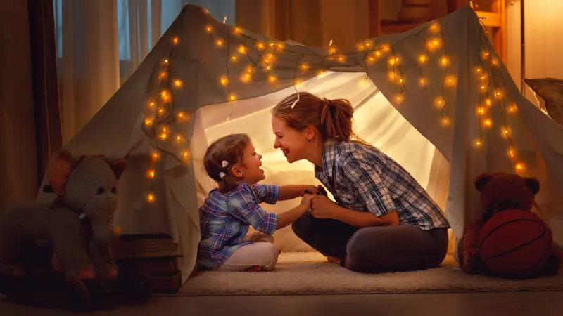 mother and daughter playing at home in a tent mother and daughter playing at home in a tent