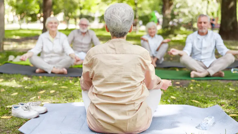 instructor leading meditation for group of elderly people instructor leading meditation for group of elderly people