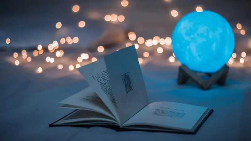 open book, sparkling lights, glowing blue ball