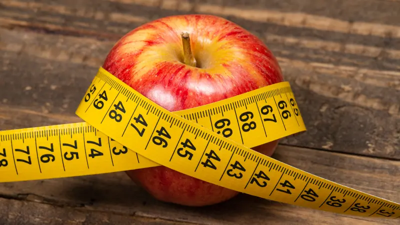 Apple with measuring tape, symbolizing overweight and metabolic syndrome