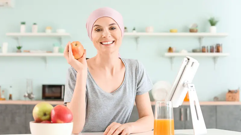 Woman after chemotherapy in kitchen at home