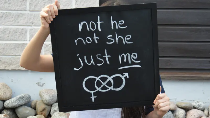 Confident teenager gives important message about being happy with your own identity. Concept of gender fluidity or non-binary gender identity. Confident teenager gives important message about being happy with your own identity. Concept of gender fluidity or non-binary gender identity.