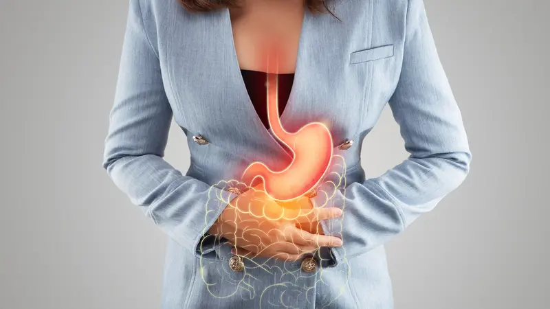 The illustration of stomach and large intestine is on the woman's body against gray background.
