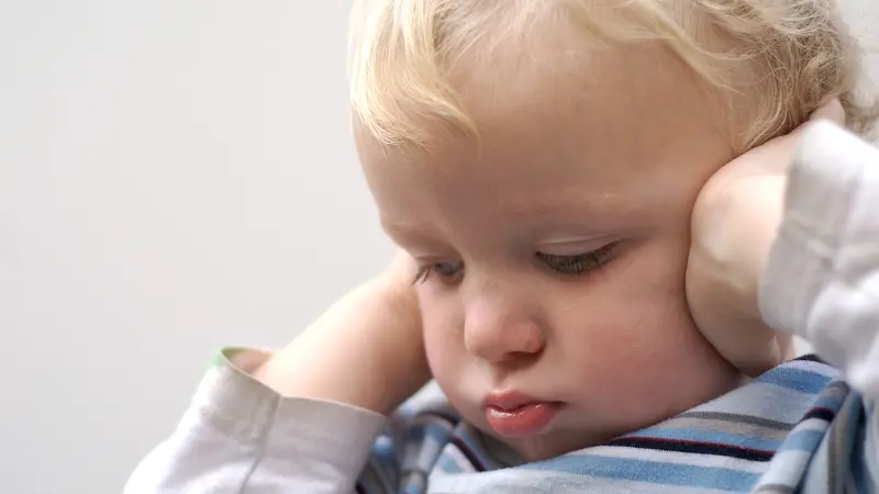 Young boy covering ears