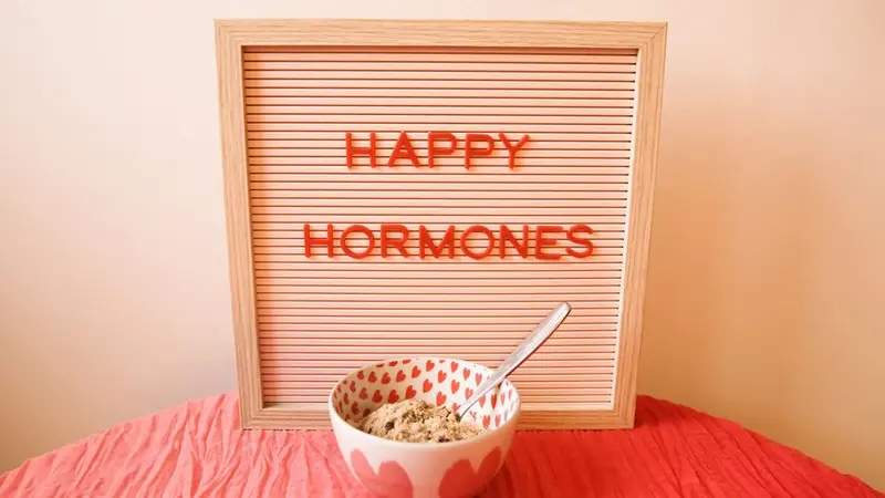 Optimizing Your Monthly Cycle to Live Your Best Life with Alisa Vitti Image of a sign board with the letters Happy Hormones with a bowl of ice cream in front sitting on a table covered in a crinkly pink tablecloth