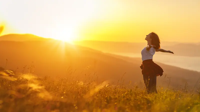 Happy woman on the sunset in nature in summer with open hands Happy woman on the sunset in nature in summer with open hands
