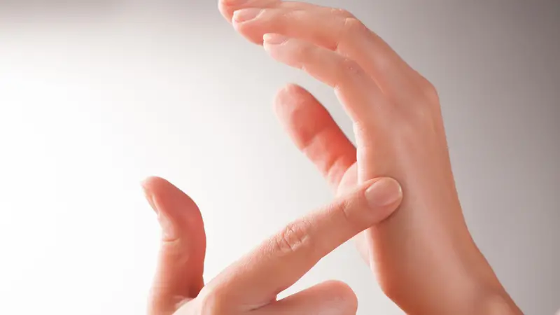 Woman doing Emotional Freedom Techniques (EFT) tapping on the karate chop point.