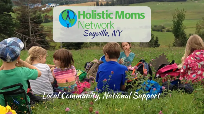 children having a snack in a field, holistic moms network logo top center with Sayville NY chapter, bottom center reads Local Community, National Support
