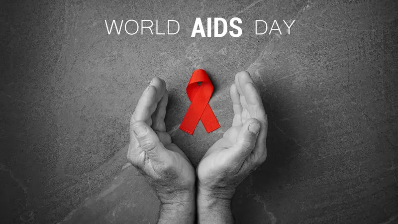 Red ribbon in hands on gray background, World AIDS Day, symbol of fight against HIV and AIDS Red ribbon in hands on gray background, World AIDS Day, symbol of fight against HIV and AIDS