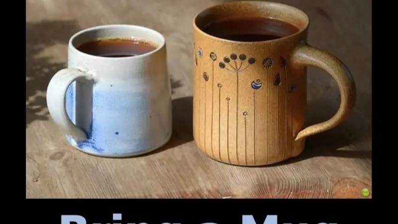 2 hand crafted mugs sitting on a wooden table with black border. At bottom reads bring a mug