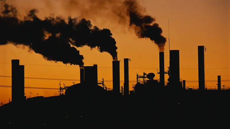 Factory at sunset. These are smokestacks contributing to the pollution in the air.