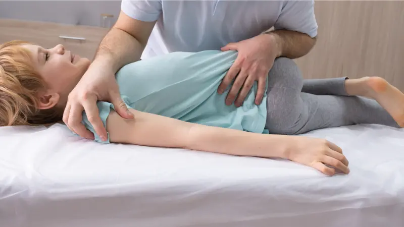 An osteopathic doctor is working with the child. An osteopathic doctor is working with the child.