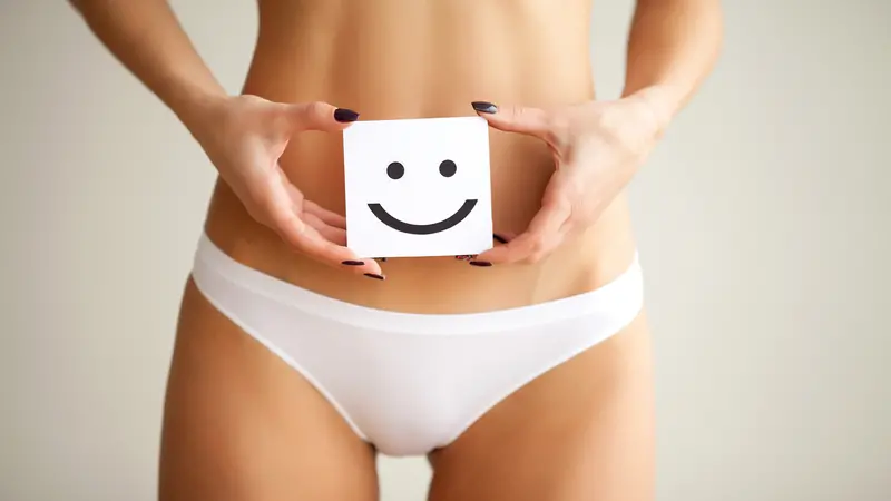 Woman holding paper with smile mark over her stomach. Healthy digestion concept.