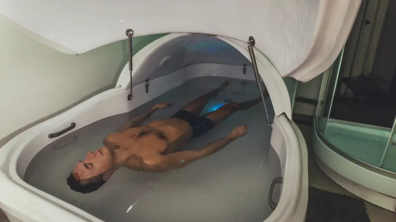 Relaxed man is floating in a sensory deprivation tank.