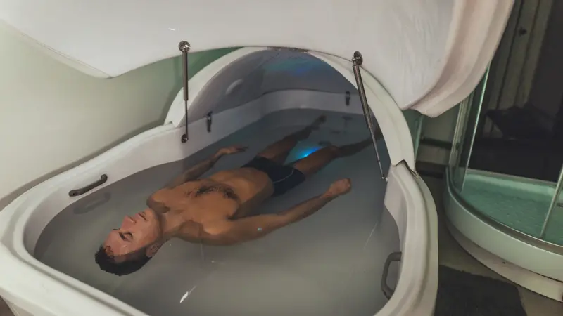 Relaxed man is floating in a sensory deprivation tank. Relaxed man is floating in a sensory deprivation tank.