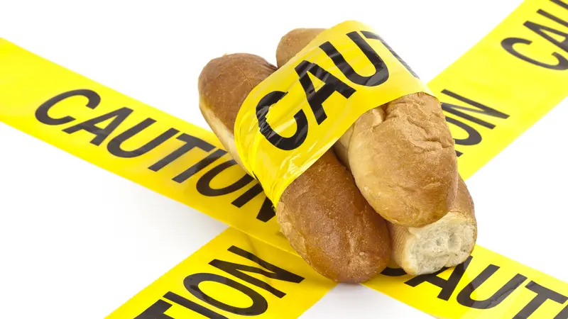 Dietary warning for gluten-related disorders (Slices of fresh French bread wrapped in yellow caution tape)