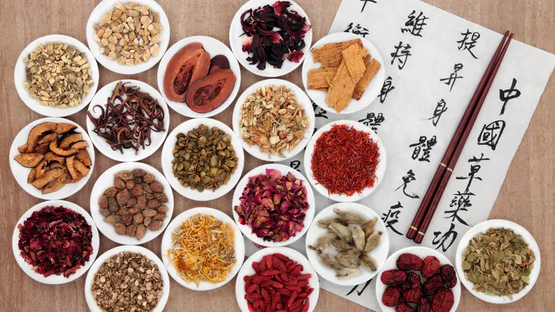 Traditional chinese herbal medicine with mandarin calligraphy on rice paper. Translation describes the medicinal functions to maintain body and spirit health and balance energy.