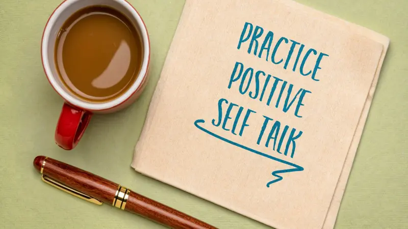 practice positive self talk - insoirational advice on a napkin with a cup of coffee, positive affirmation and personal development concept