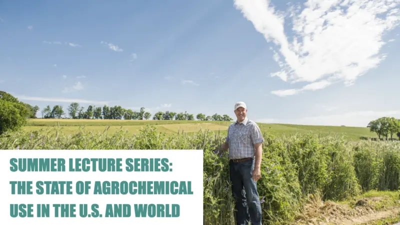 Man smiling and standing in a crop field 