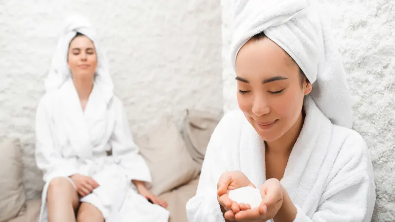 Halotherapy. Salt therapy. Portrait Asian woman with towel on her head, enjoying during treatment in a salt room at a spa. 